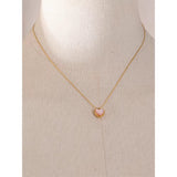 18k Gold Plated Pink Shell Heart Necklace placed on a show piece
